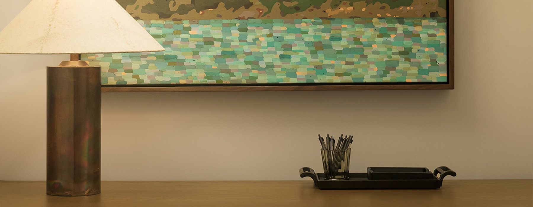 a desk with a lamp and wall art